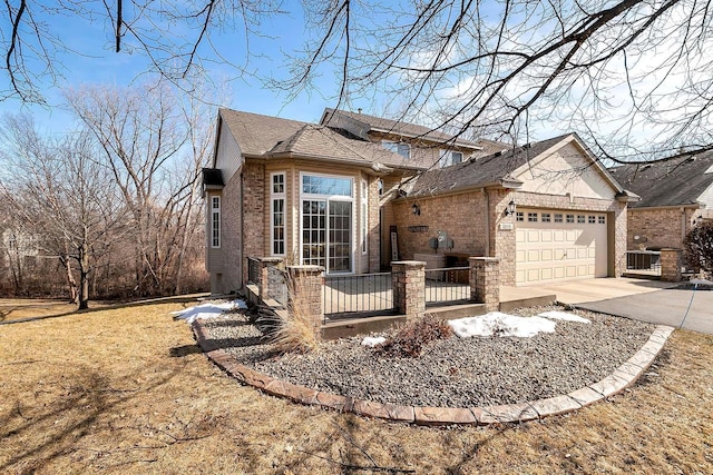 ranch-style house featuring brick siding, driveway, a shingled roof, and a garage