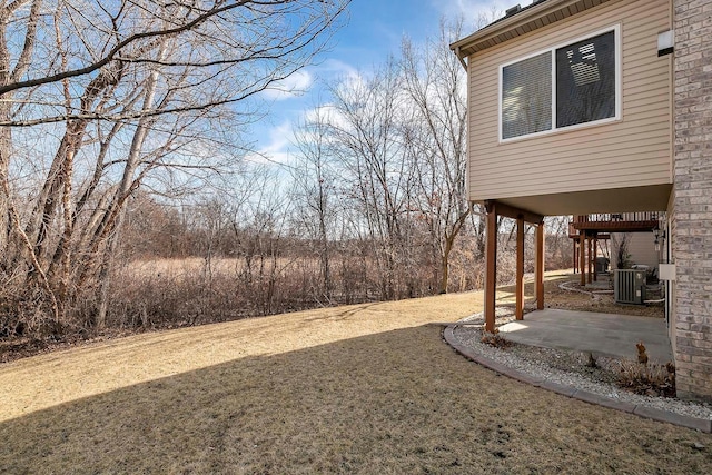 view of yard with central air condition unit and a patio area