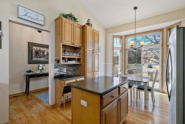 kitchen featuring light wood finished floors, lofted ceiling, a chandelier, and freestanding refrigerator