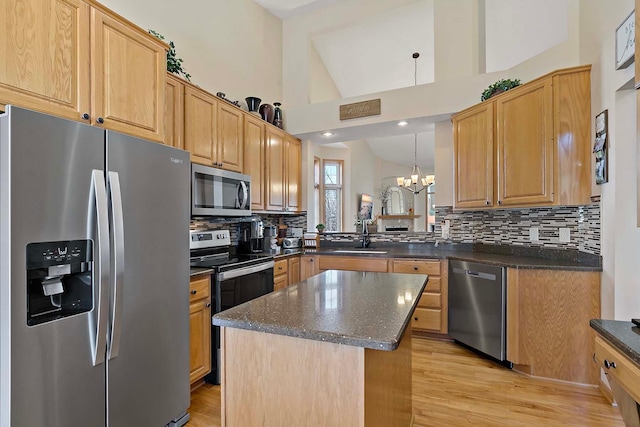 kitchen featuring a sink, decorative backsplash, appliances with stainless steel finishes, and an inviting chandelier