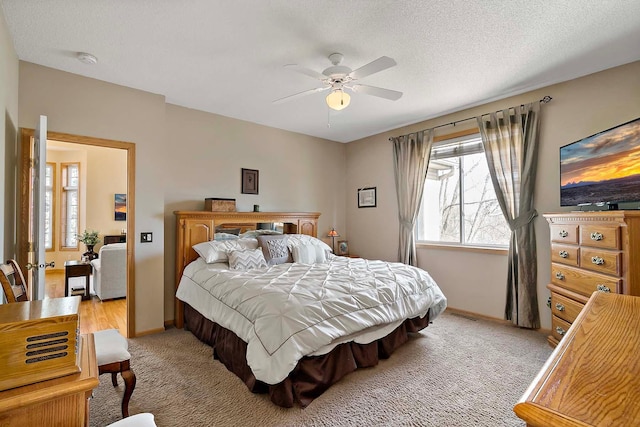 bedroom with baseboards, light carpet, a textured ceiling, and ceiling fan