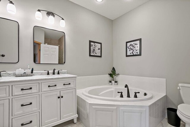 full bath featuring double vanity, toilet, a bath, and a sink