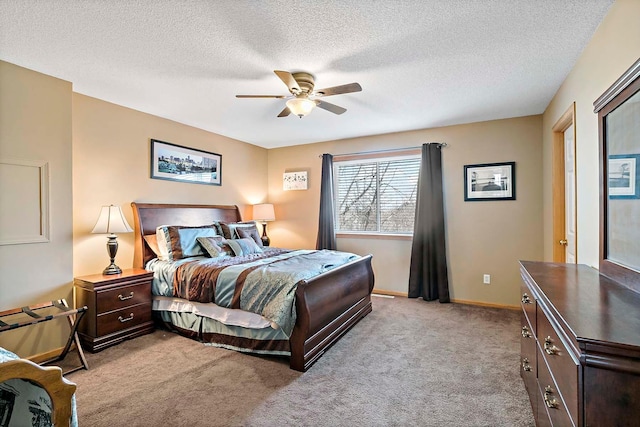 bedroom with light carpet, a textured ceiling, baseboards, and a ceiling fan