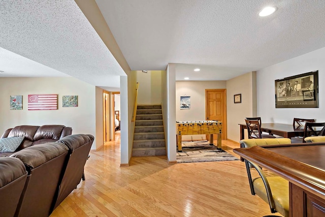 living room with light wood finished floors, stairway, recessed lighting, and a textured ceiling