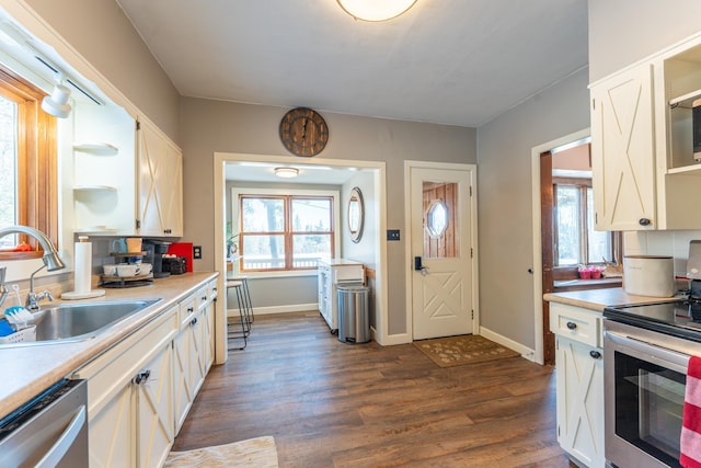 kitchen with open shelves, dark wood finished floors, stainless steel appliances, white cabinetry, and a sink