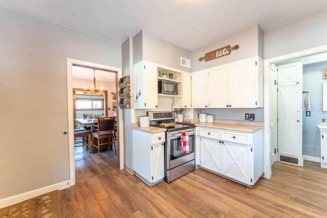 kitchen featuring visible vents, wood finished floors, black microwave, stainless steel electric range oven, and a chandelier