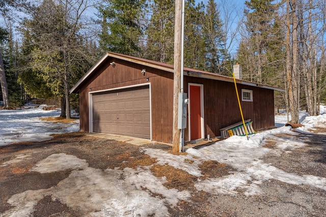 snow covered garage with a garage