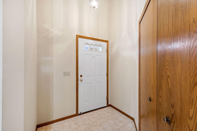 foyer entrance featuring baseboards and light floors