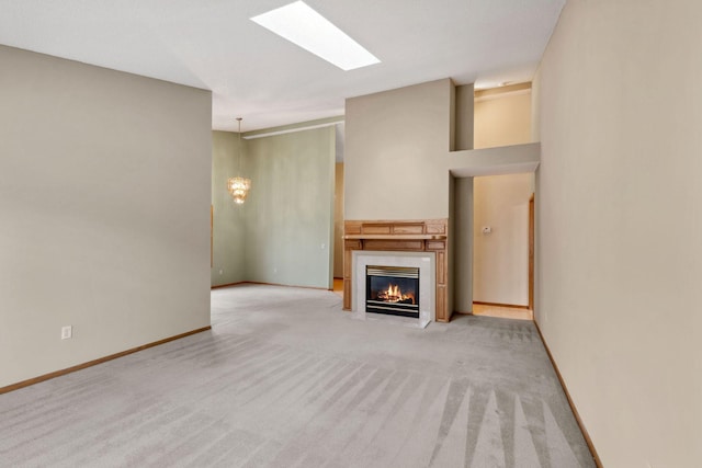 unfurnished living room featuring baseboards, a fireplace with flush hearth, and light colored carpet