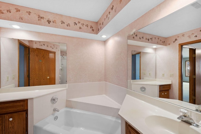 bathroom featuring wallpapered walls, a bath, vanity, and visible vents