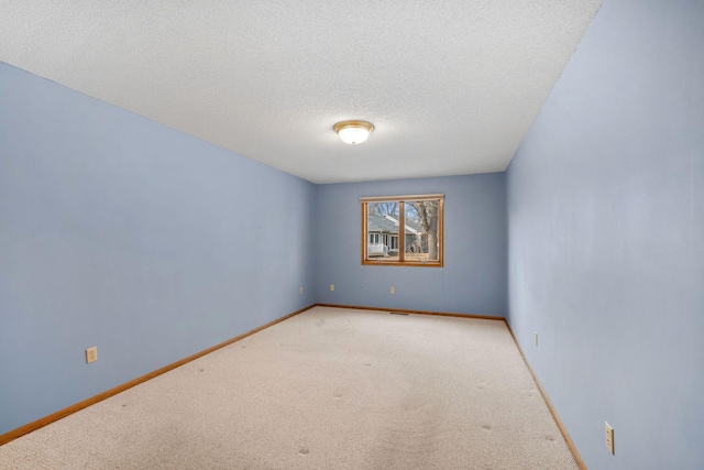 carpeted empty room featuring visible vents, baseboards, and a textured ceiling