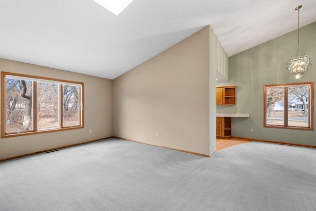 unfurnished living room with visible vents, baseboards, light colored carpet, and a chandelier