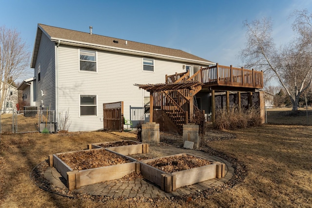 back of house with fence, stairway, a deck, a vegetable garden, and a gate