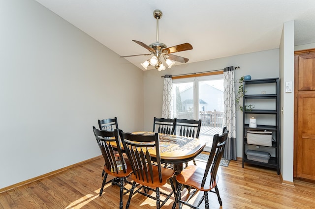 dining space with light wood-type flooring, baseboards, ceiling fan, and vaulted ceiling