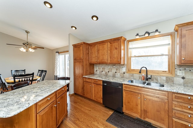 kitchen with vaulted ceiling, plenty of natural light, black dishwasher, and a sink