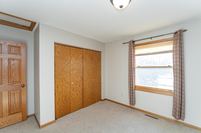 carpeted bedroom with a closet, visible vents, attic access, and baseboards