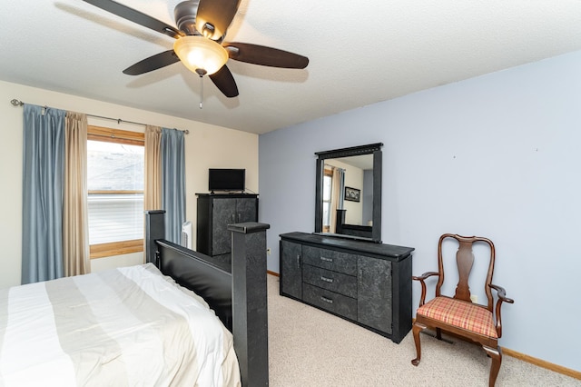 bedroom featuring light carpet, ceiling fan, a textured ceiling, and baseboards