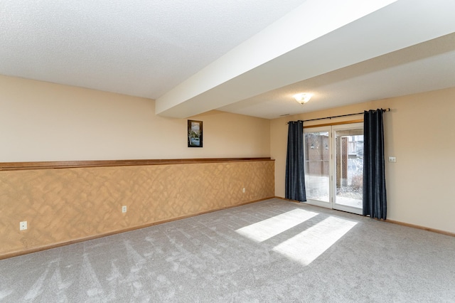 empty room with baseboards, a textured ceiling, carpet flooring, and wallpapered walls