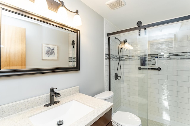 full bath with visible vents, a shower stall, toilet, and vanity