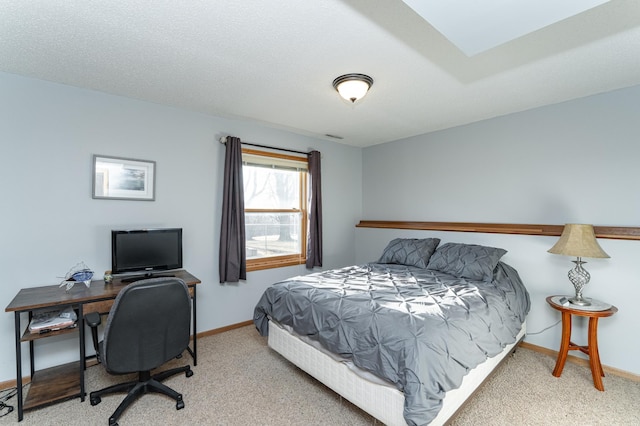 carpeted bedroom featuring baseboards and a textured ceiling