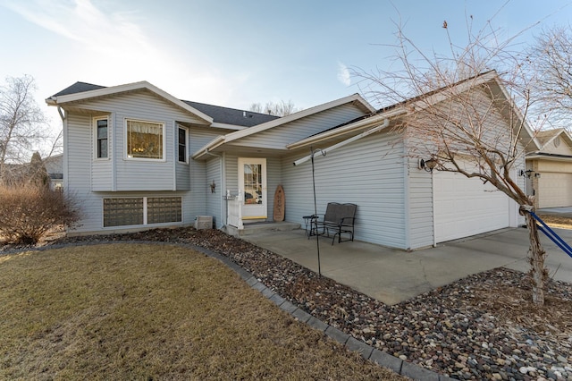 split level home featuring a garage, a front yard, and driveway