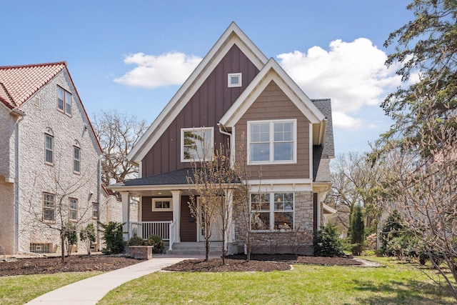 38 Mississippi River Blvd N, Saint Paul, MN 55104 - craftsman-style house with board and batten siding, a porch, stone siding, a front lawn, and roof with shingles