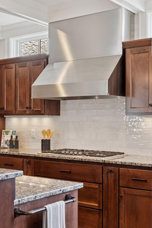 38 Mississippi River Blvd N, Saint Paul, MN 55104 - kitchen featuring wall chimney range hood, stainless steel gas stovetop, tasteful backsplash, and light stone counters