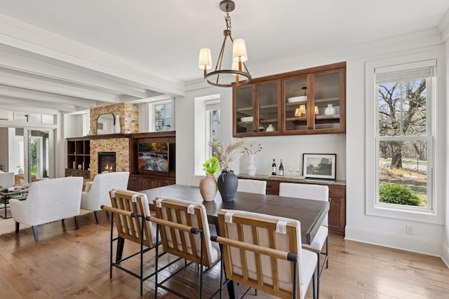 38 Mississippi River Blvd N, Saint Paul, MN 55104 - dining room featuring a chandelier, beamed ceiling, light wood finished floors, baseboards, and a large fireplace