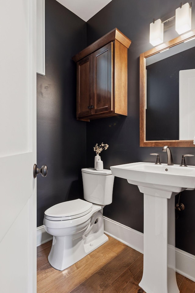 38 Mississippi River Blvd N, Saint Paul, MN 55104 - half bathroom featuring baseboards, toilet, and wood finished floors