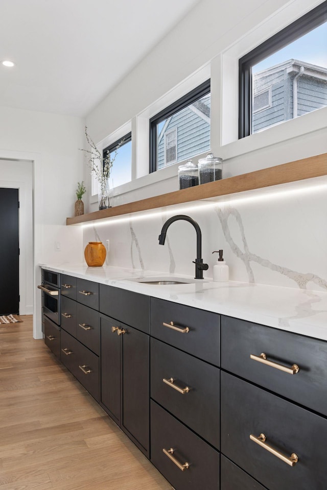 6008 Oaklawn Ave, Edina, MN 55424 - kitchen with light countertops, light wood-style flooring, oven, and dark cabinets