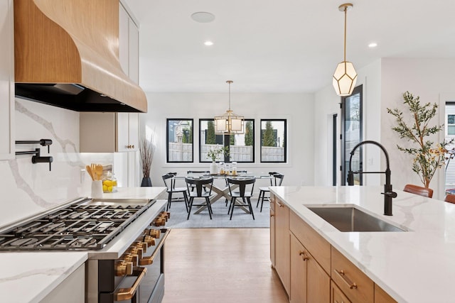 6008 Oaklawn Ave, Edina, MN 55424 - kitchen with stainless steel range with gas cooktop, wall chimney range hood, light wood-type flooring, recessed lighting, and light stone counters