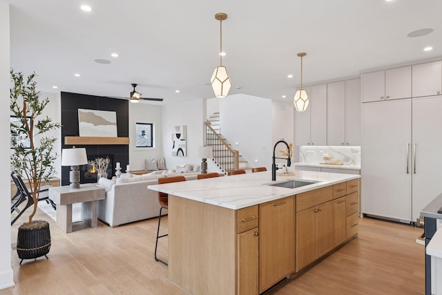 6008 Oaklawn Ave, Edina, MN 55424 - kitchen featuring light wood-style flooring, hanging light fixtures, an island with sink, recessed lighting, and a ceiling fan