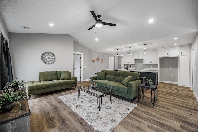 living room with vaulted ceiling, baseboards, ceiling fan, and dark wood-style flooring