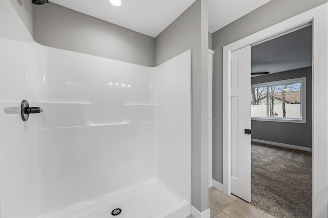 full bath featuring a shower stall, baseboards, and tile patterned floors