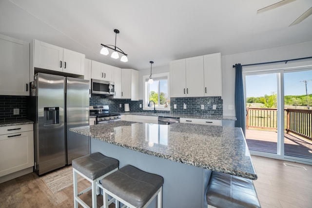 18492 120th St SE, Big Lake, MN 55309 - kitchen featuring appliances with stainless steel finishes, light wood-type flooring, a kitchen bar, and vaulted ceiling