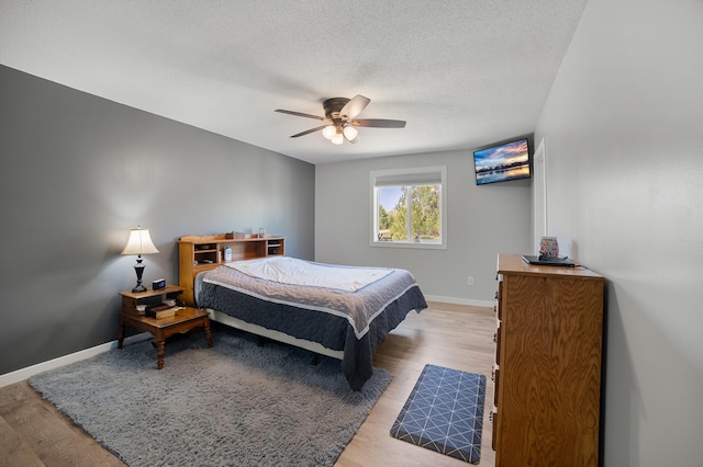 18492 120th St SE, Big Lake, MN 55309 - bedroom featuring light wood-style floors, a textured ceiling, and a ceiling fan
