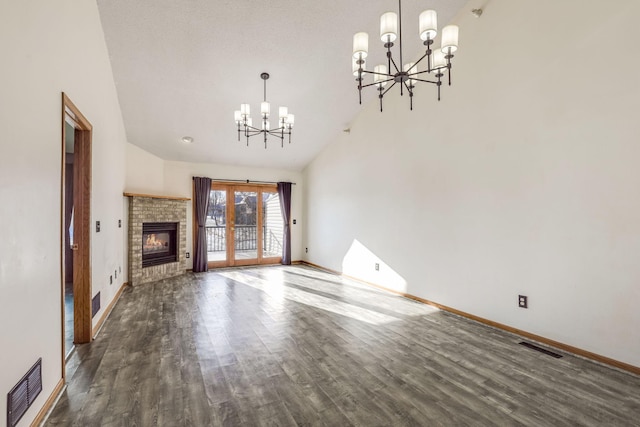 unfurnished living room featuring dark wood finished floors, a notable chandelier, visible vents, and high vaulted ceiling