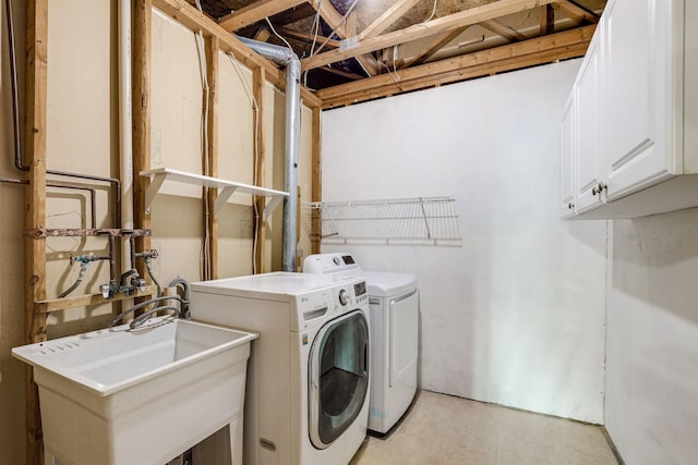 washroom featuring a sink, cabinet space, and washing machine and dryer