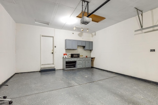 garage featuring a garage door opener and baseboards