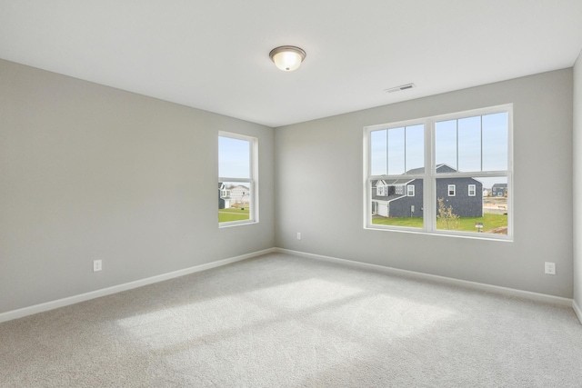 empty room featuring visible vents, baseboards, and carpet