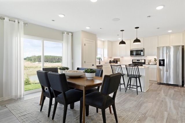 dining room with light wood-style flooring and recessed lighting