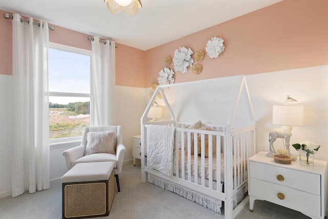 bedroom with a crib and carpet