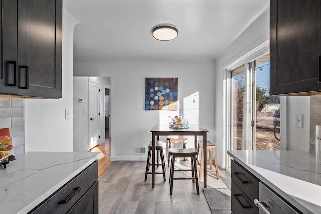 dining room with baseboards, visible vents, and light wood finished floors