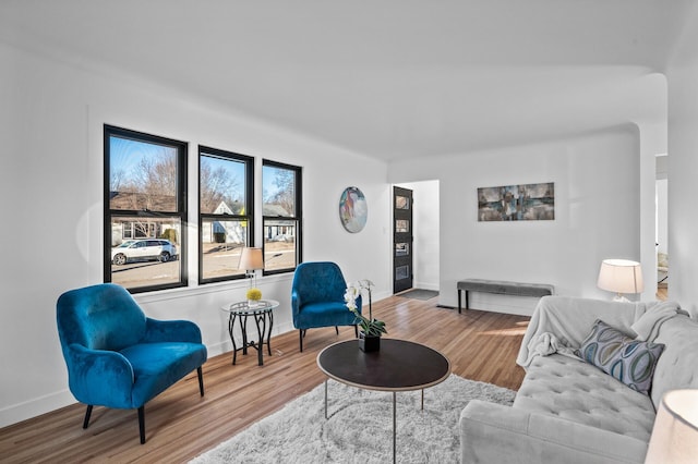 living area with baseboards and wood finished floors