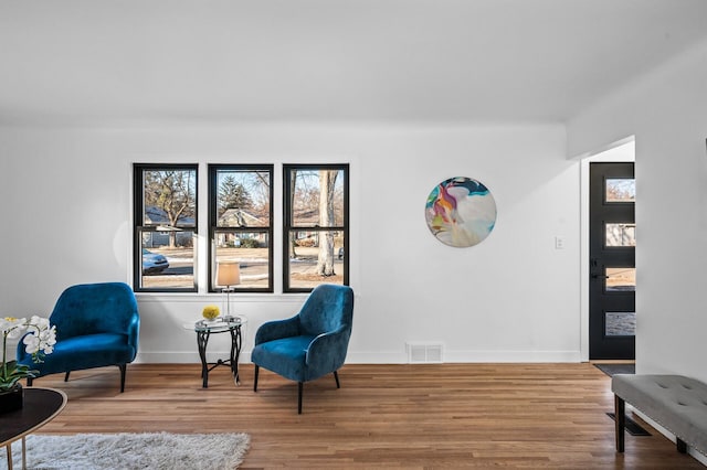 sitting room with visible vents, baseboards, and wood finished floors