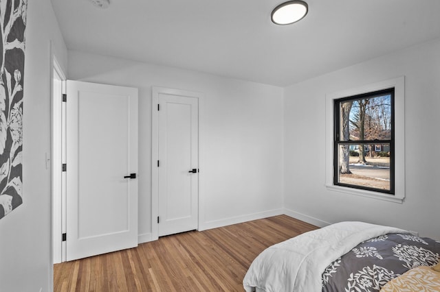 bedroom featuring wood finished floors and baseboards