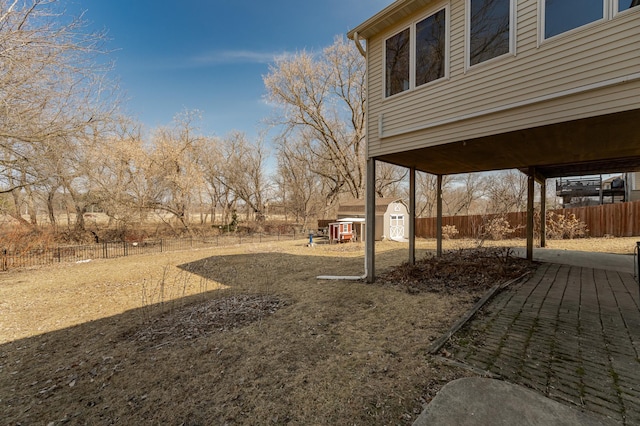 view of yard featuring an outbuilding, a storage shed, and a fenced backyard