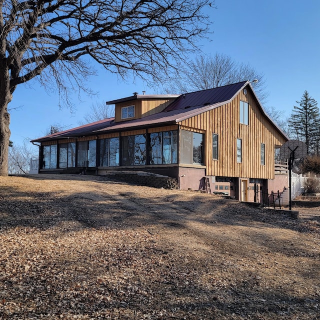 exterior space with metal roof and fence