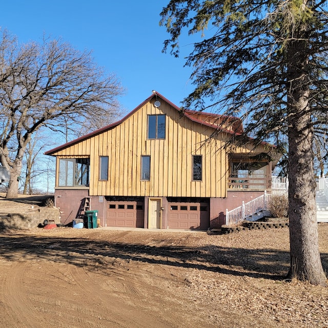 exterior space featuring a garage, central AC, and dirt driveway