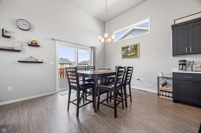 dining room featuring baseboards, a notable chandelier, dark wood-style floors, and high vaulted ceiling